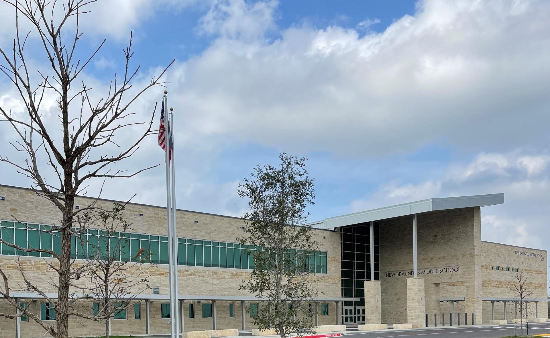 New Braunfels ISD – New Braunfels Middle School  New Braunfels Middle School is a 190,682 SF, two-story building on a 67 acre site.  Construction elements include a structural void form slab, steel frame, modified bitumen and standing seam roofing, porcelain tile, and LVT flooring.  The exterior is clad with face brick, natural stone, and metal panels.  The facility includes classrooms, wood floor gymnasiums, science labs, food service, administration, and fine arts areas.  On site improvements include concrete paving, covered walkways, site utilities, athletic fields, running track, and tennis courts.  Back to Portfolio 