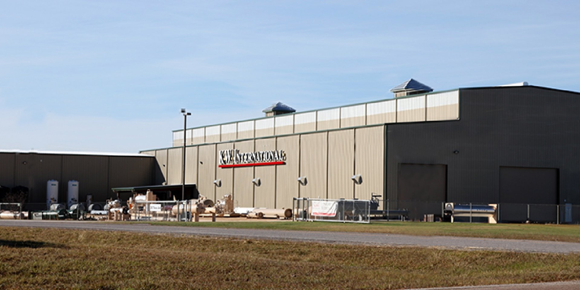 KW International  When KW International, a major oil field supply manufacturer, built a new facility from scratch, they chose Drymalla Construction for complete Design Build services.&nbsp; Drymalla designed and engineered the project from raw land to a finished heavy industrial facility.&nbsp; The project consisted of developing 20 acres of raw land complete with new electrical service, sanitary service, natural gas service, domestic water, limestone base storage and staging area, concrete paving and security fencing.&nbsp; The industrial portion consisted of approximately 130,000 SF of 48’ tall pre-engineered metal buildings that consist of fabrication, assembly, shipping and receiving, hydro testing, stress furnace, sandblast, high VOC paint application with filtering and x-ray buildings.&nbsp; These buildings house an intricate processed gas mechanical piping system, as well as an electrical system designed for 60+ work stations.&nbsp; For material handling there are (9) large bridge cranes and (50) job cranes strategically placed, as well as a ground level rail system and foundation that connects all of the industrial structures.&nbsp; The campus houses over 10,000 SF of office space complete with modern and up to date conveniences.  Back to Portfolio 